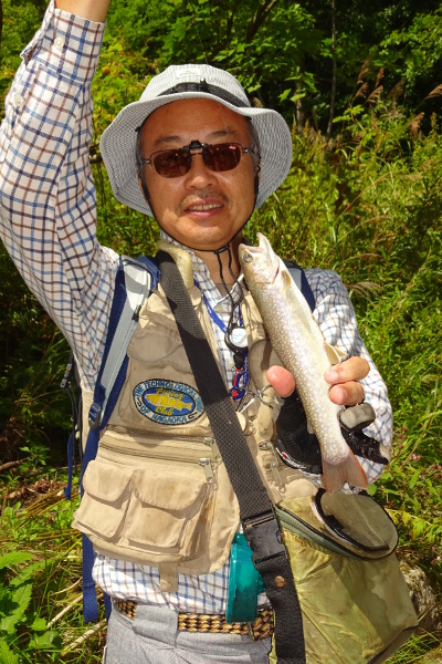 谷倉さんのベストには、釣り同好会のワッペン　撮影：岡田君