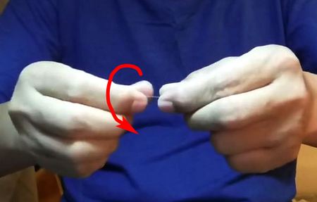 Move the thumb of your dominant hand forward, and move the index finger backwards.